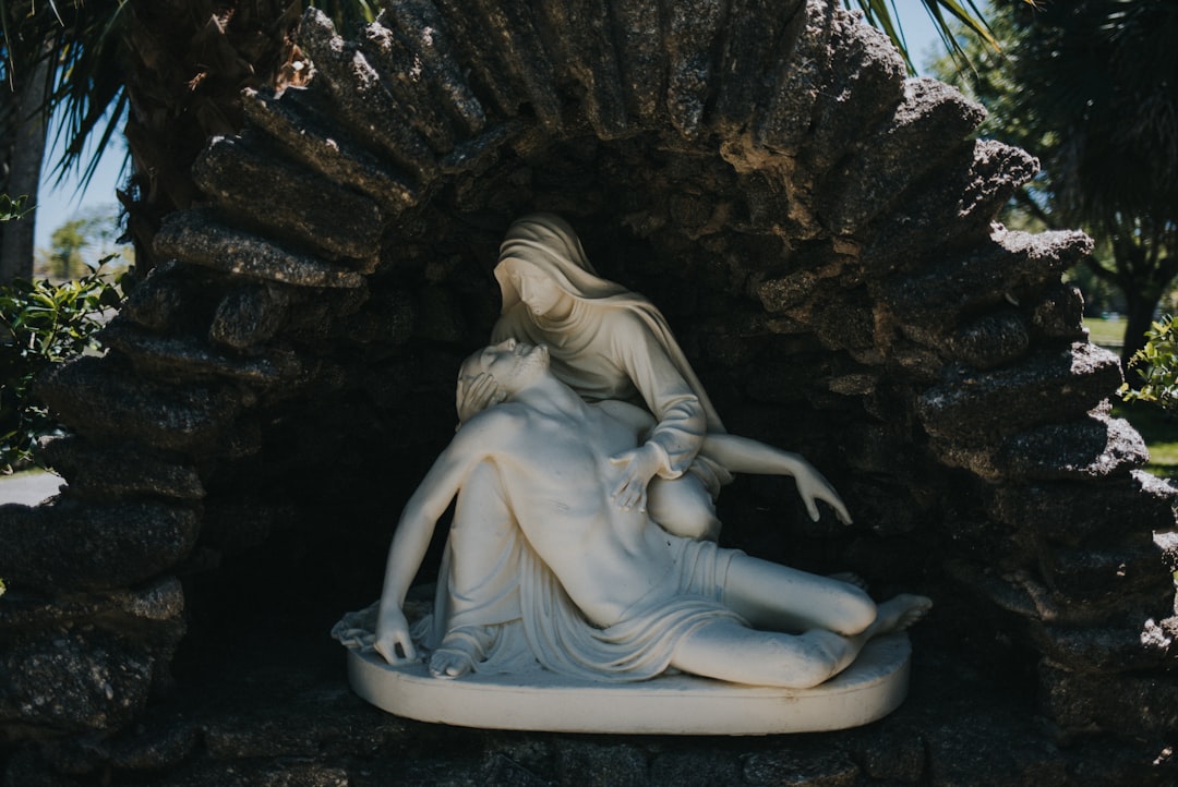 a statue of a woman laying on top of a stone wall a statue of a woman laying on top of a stone wall